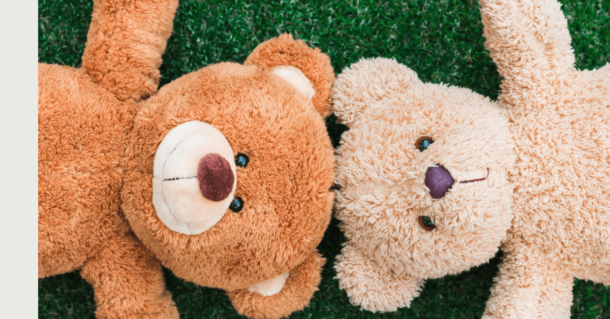 Two handmade bears resting in grass